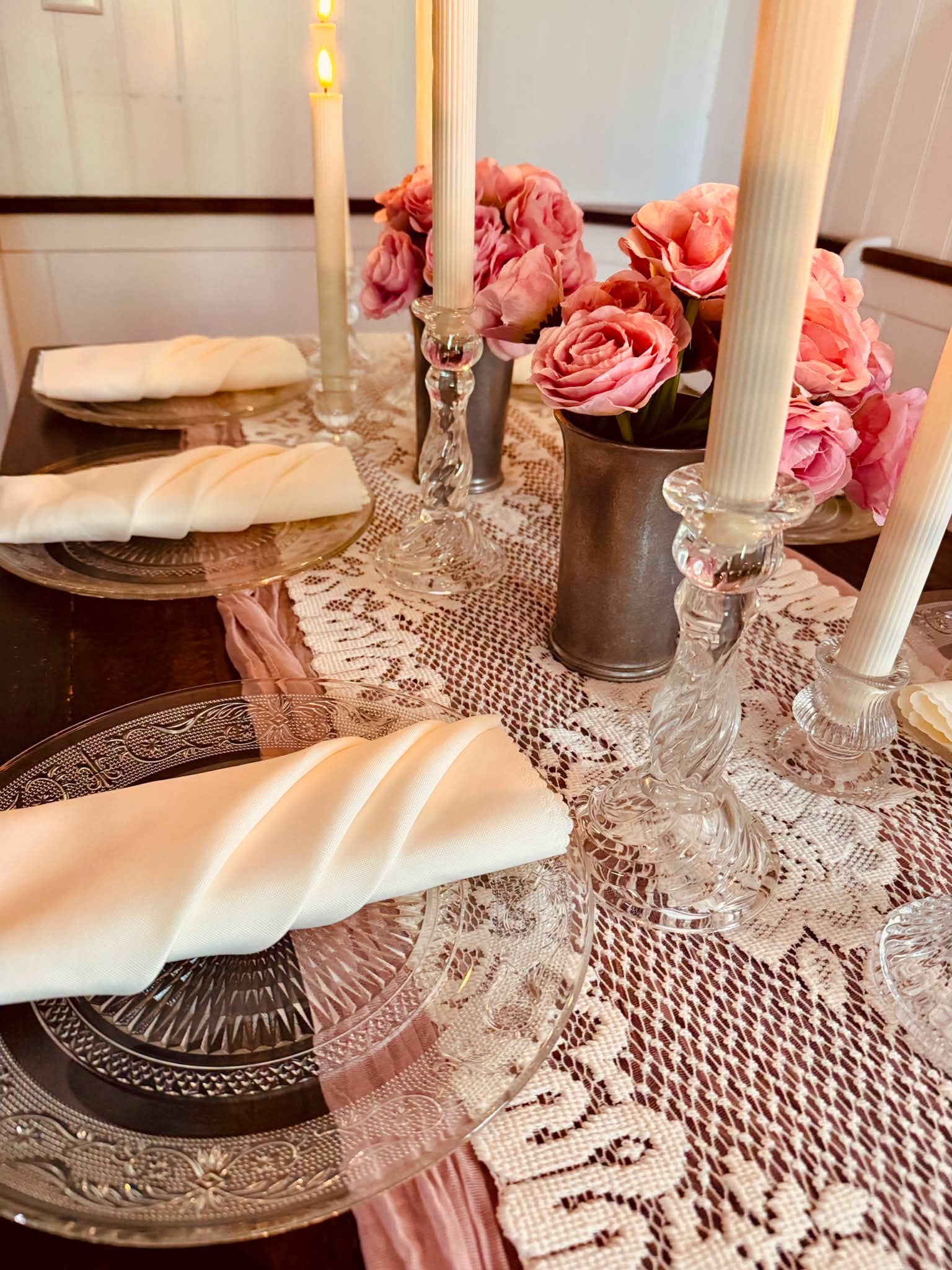 Romantic pink roses and lace table setting with taper candles